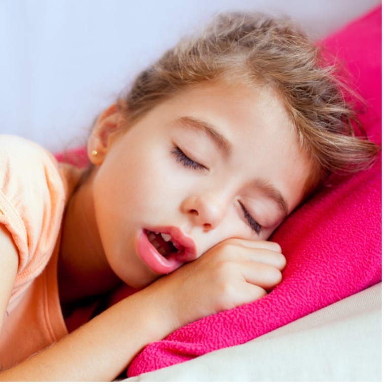 A young person lying down with the eyes closed mouth breathing