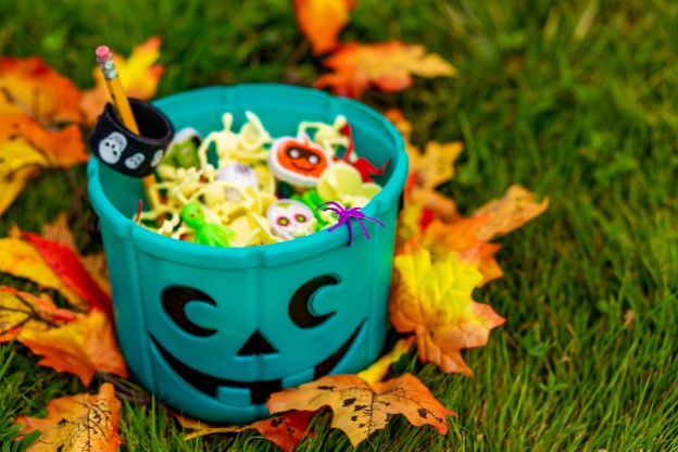 A bucket of halloween objects on grass