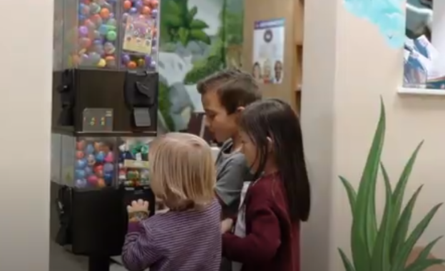 A group of children standing next to a vending machine