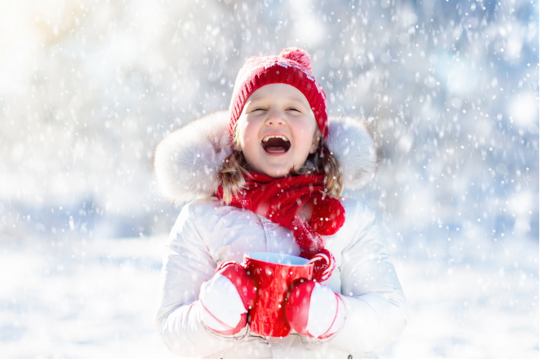 A child in a red hat and scarf holding a red mug in the snow, Celebrate the Season: 12 Pediatric Dental Tips for a Radiant Holiday Smile