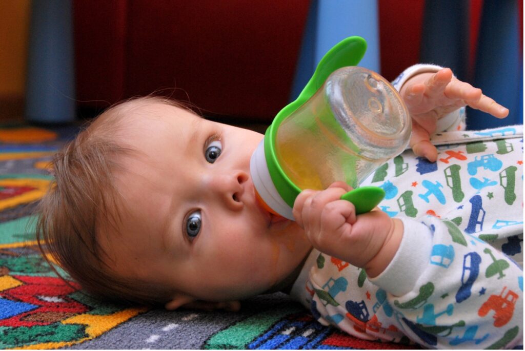 A baby drinking from a bottle, how sugar affects children's teeth